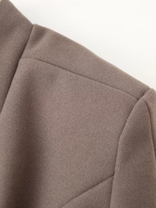 Detail of shoulder seam and stand-up collar on taupe winter wool coat with padding