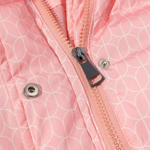 Macro detail of pink winter jacket featuring waterproof fabric and silver snap buttons