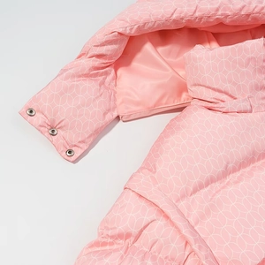 Detail of pink winter puffer jacket featuring white geometric prints and silver sleeve snaps