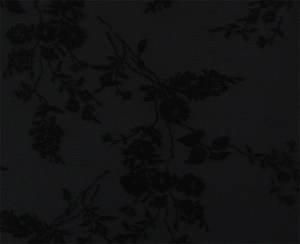 Detailed macro view of black lace fabric with velvet floral and branch patterns