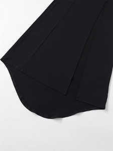 Detail of a black asymmetrical dress featuring side slits and a high-low hemline