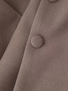 Macro shot of texture and button detail on high-quality coffee wool blend coat