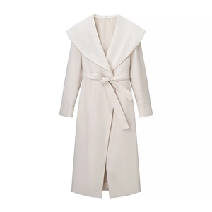 Détail du manteau long en laine crème avec col châle et ceinture nouée à la taille