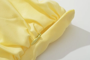 Close-up of pale yellow woven fabric with a seamless matching invisible zipper