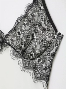 Detailed macro view of delicate black floral lace with elegant eyelash lace trim edges