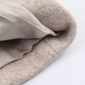 Détail de la texture en laine avoine et doublure en satin lisse d'un chapeau d'hiver