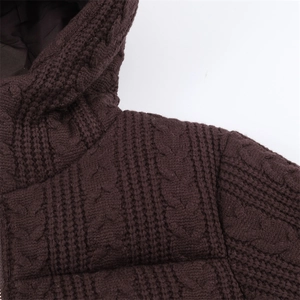 Detail of dark brown cable knit hooded jacket featuring thick wool texture and warm lining