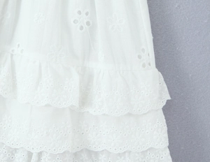 Detail von weißer Broderie Anglaise Stickerei und mehrlagigen Rüschen aus Baumwolle