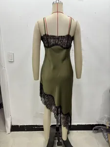 Detail of satin dress with black lace trim and asymmetrical hem in army green color