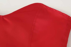 Detaillierte Makroansicht des roten Satinstoffs und der feinen Nähte am Vintage-Korsettkleid