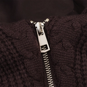 Detail of dark brown cable-knit jacket featuring high-quality silver metal zipper hardware