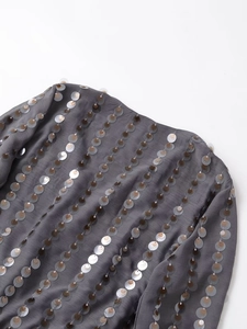 Macro detail of vertical sequins in silver and gold on grey long sleeve bodysuit fabric