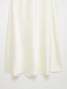 Detail of the smooth cream satin fabric hem with elegant draped folds and high-quality stitching