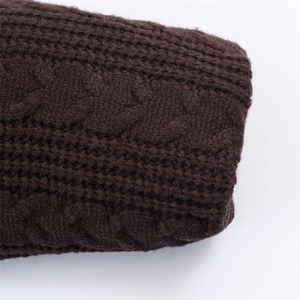 Macro view of dark brown chunky cable knit texture and thick ribbed cuffs on winter coat