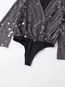 Detail of grey sequined wrap V-neck bodysuit with long sleeves and glittery round sequins