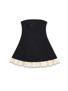 Detail view of the black strapless top with white pleated hem and A-line silhouette