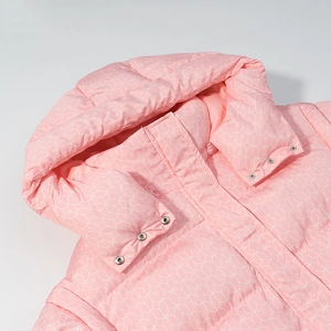 Gros plan d'une doudoune rose à capuche avec motifs géométriques et boutons-pression