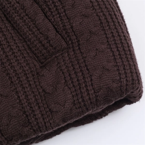 Detail of dark coffee cable knit pattern with thick textured weave on winter hooded coat
