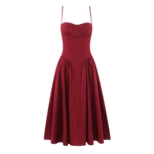 Détail de robe corset rouge à fines bretelles avec coutures et jupe évasée à plis