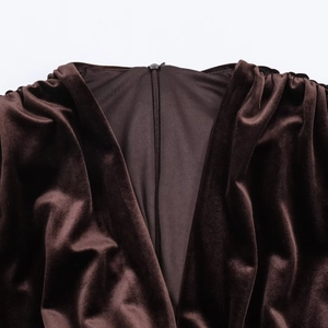 Détail de robe en velours marron foncé montrant la fermeture éclair et les plis d'épaule