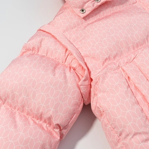 Détail de doudoune rose matelassée avec imprimé feuille blanc et bouton pression argenté