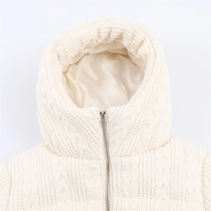 Close-up of cable knit texture and metal zipper on this cream hooded winter jacket