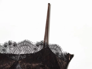 Detailed view of black lace dress featuring eyelash trim and satin spaghetti straps