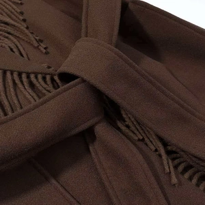 Detailed close-up of dark brown wool coat featuring thick fringe trim and matching waist tie