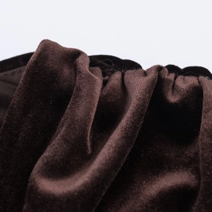 Détail du tissu en velours marron foncé avec plis élastiques et texture douce