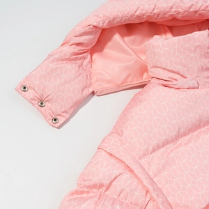 Détail d'une veste en coton rose à fleurs avec fermeture éclair amovible et boutons argentés