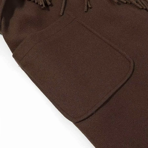 Detail of dark coffee wool coat featuring a large patch pocket and stylish fringe trim