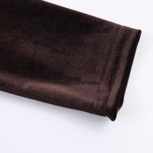 Gros plan sur la texture du velours plissé et les coutures soignées de la robe midi