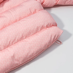 Vue macro du tissu rose matelassé avec motifs géométriques blancs et détails de couture