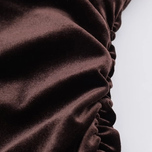 Gros plan sur la texture du velours marron foncé avec détails de coutures froncées