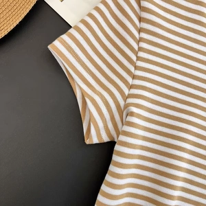 Vista dettagliata che mostra le cuciture sottili e la trama a righe kaki di una t-shirt