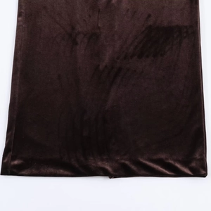 Vue macro détaillée de la texture du velours marron foncé et de l'ourlet de la robe