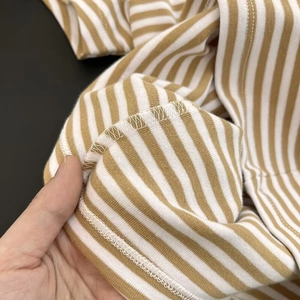Dettaglio delle cuciture piatte e trama in maglia su una maglietta a righe a maniche corte