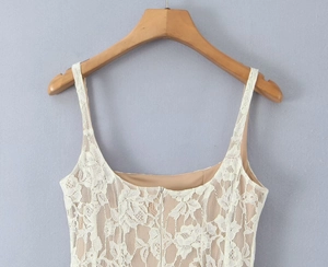 Close-up of intricate white floral lace bodice with nude lining and slim spaghetti straps