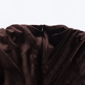 Gros plan sur la fermeture éclair invisible d'une robe en velours marron foncé chic