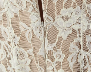 Close-up of delicate floral lace fabric with a concealed zipper on ivory dress back