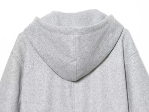 Detail of light grey hooded jacket featuring thick textured fleece fabric on the back