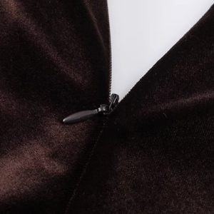 Gros plan d'une fermeture éclair invisible sur une robe ajustée en velours marron