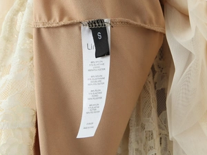 Detailed fabric label showing 89% nylon material and lace texture of the dress