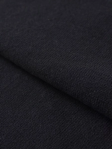 Close-up detail of high-quality black knit fabric showing soft texture and fine stitching