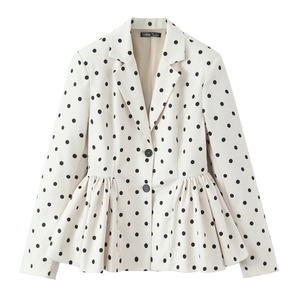 Close-up detail of white polka dot blazer featuring feminine peplum hem and black buttons