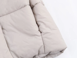 Close-up of quilted winter jacket fabric with matte finish and high-quality stitching detail