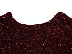 Detail of burgundy sequin dress showing fabric texture and neckline craftsmanship