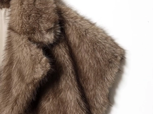 Close-up of the thick brown faux fur texture and smooth fabric lining of the winter vest