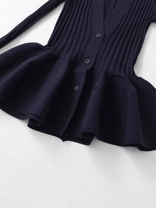 Detailed macro view of the ribbed knit fabric texture and elegant peplum hem design