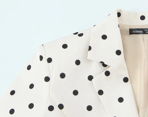 Close-up of beige polka dot blazer collar with interior Aveloria brand size label